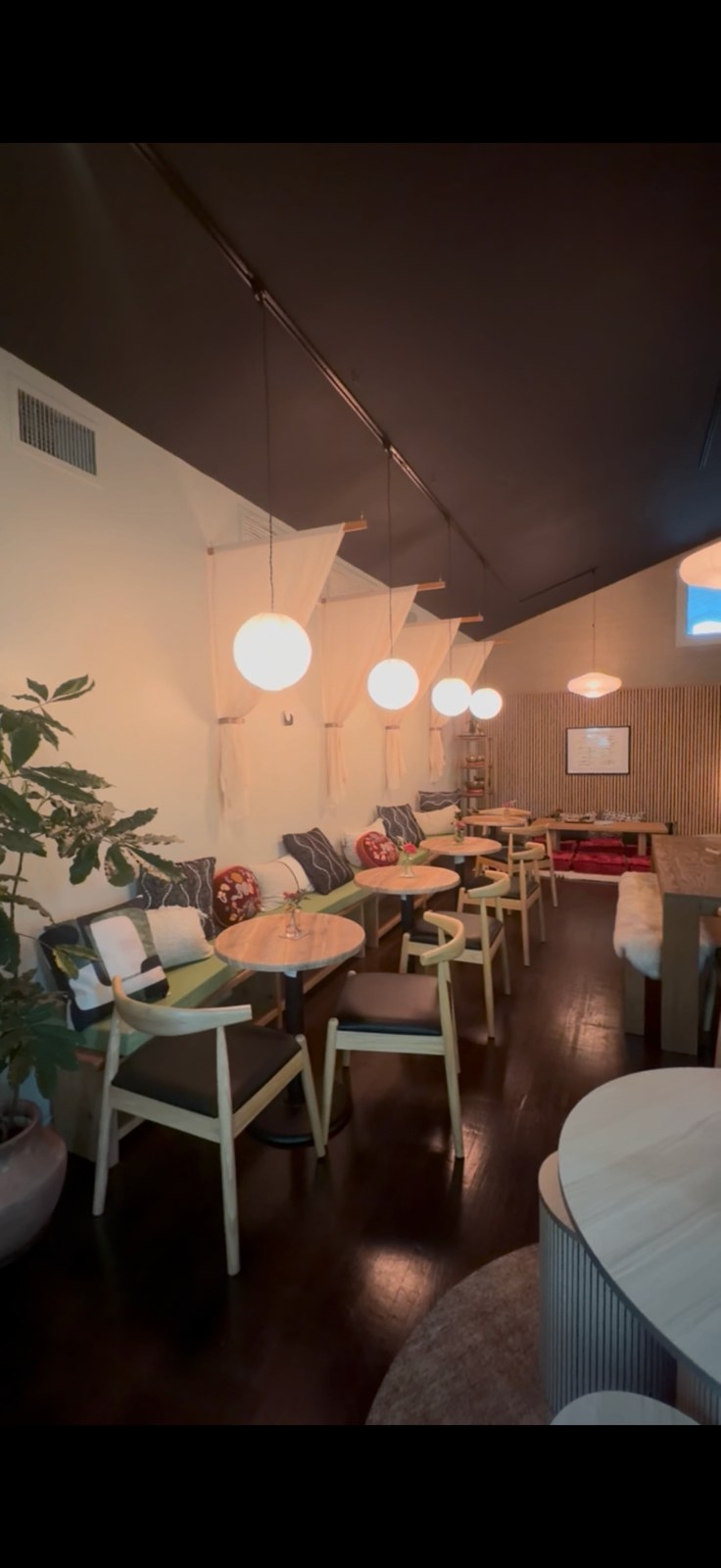 Banquette seating and paper globe pendants in the evening